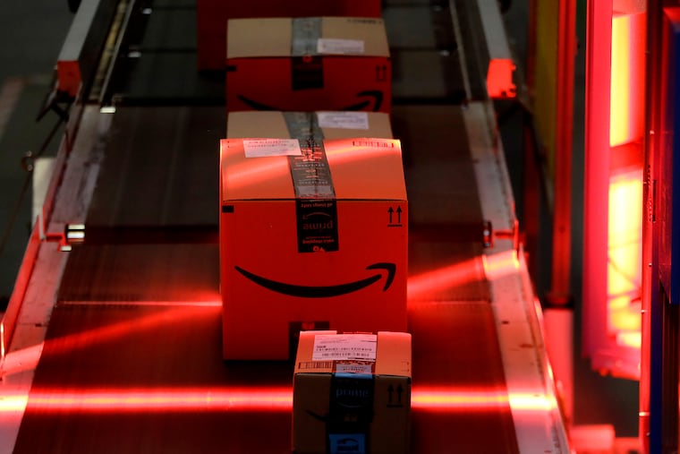 Packages riding on a belt are scanned to be loaded onto delivery trucks at the Amazon Fulfillment center in Robbinsville Township, N.J., on Aug. 1, 2017. Federal work-safety investigators are looking into the death of an Amazon worker and an injury that potentially led to the death of another employee, adding to a probe already underway following a third fatality during the company's annual Prime Day shopping event in mid-July, 2022.