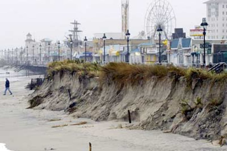 Cliffs of sand line the Ocean City boardwalk, the result of beach erosion from the nor'easter that has battered the Shore for the past two days. (Ron Tarver / Staff Photographer)