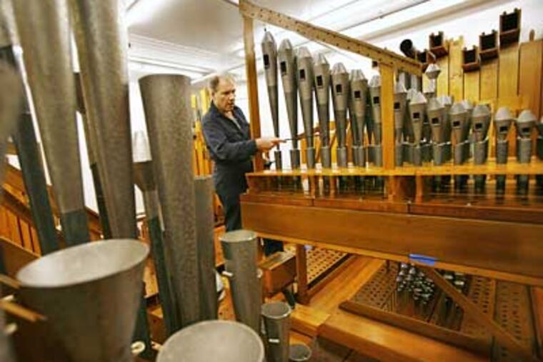 Chief of Tuning Peter Batchelder tunes the French horn in the orchestral chamber of the Wanamaker organ at Macy's in Center City. (Eric Mencher/Inquirer)
