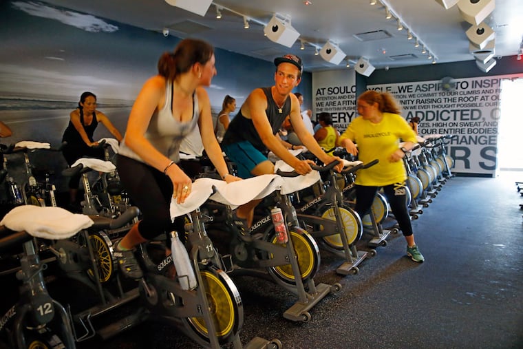 At the SoulCycle in Ardmore, friends Grace Weiner and Seth Caplan chat as they warm up before a class. The studio is the first SoulCycle in Pennsylvania.