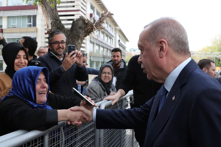 Turkey's President Recep Tayyip Erdogan shakes hands with a supporter as he arrives to speak at an assembly for religious schools, in Istanbul, Saturday, April 13, 2019. Erdogan's ruling party still appealing the results of the local elections in Istanbul, where the opposition has a razor-thin lead and Erdogan said Wednesday election results in Istanbul should be canceled over irregularities.(Presidential Press Service via AP, Pool)