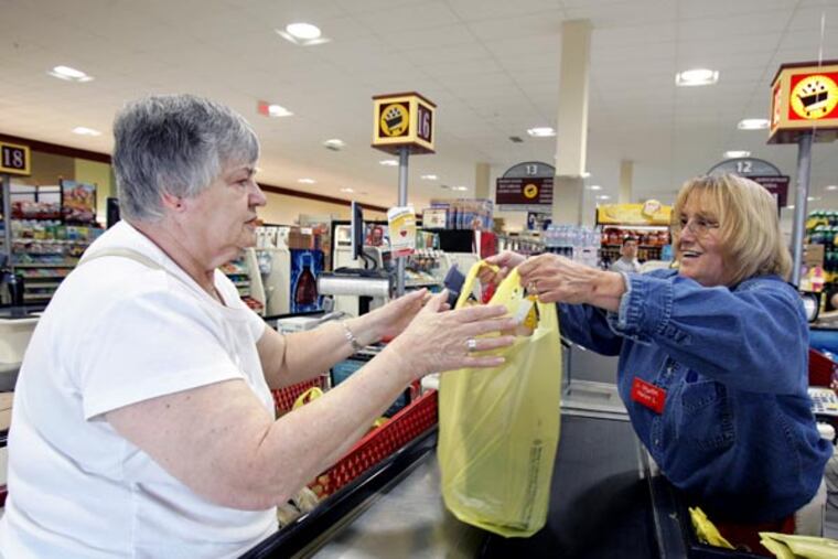Cashier Helen Ladd (right) hands Carol Grochal of Marlton a bag of her groceries at the check out of the Shop Rite in Marlton, New Jersey on June 19, 2008. Shop Rite is gaining market share, our annual survey of the Philadelphia supermarket fields shows. Who's losing? And are the non-food stores, like Wal-Mart, still growing their share? (Barbara L. Johnston/Inquirer)