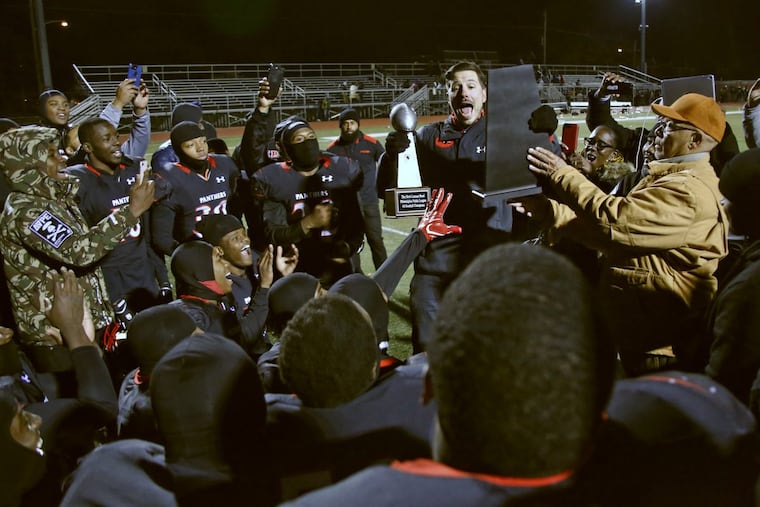 Imhotep football coach Nick Lincoln (top, middle) receives some of the title hardware after after Imhotep won the Public League Class 4A championship.