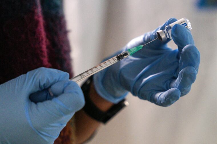 A staff member from the National Health Organisation (EODY) prepares a Johnson & Johnson vaccine booster at a refugee camp on the northeastern Aegean island of Lesbos, Greece.