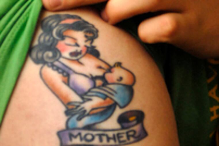 Alec Collins, 17, the oldest of Smith's six children, shows the tattoo he had done after his mother's cancer was diagnosed.