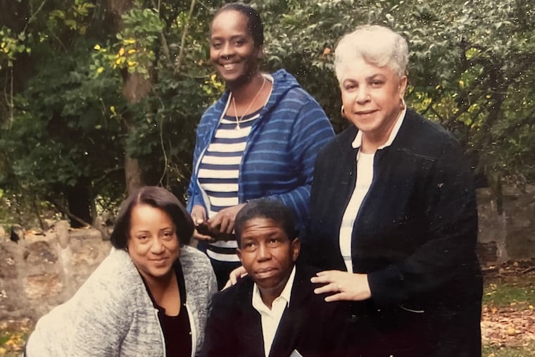 Placement of the headstone for the enslaved African people buried in Upper Dublin Friends cemetery. Avis Wanda McClinton is seated in front, in black.