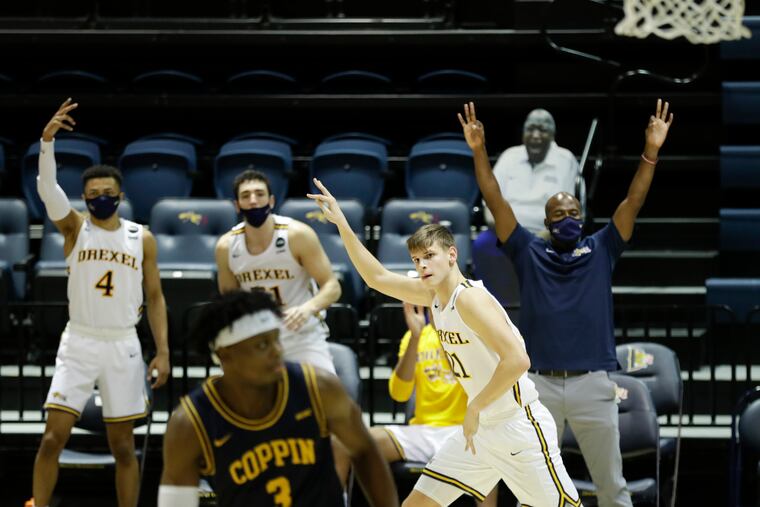 Drexel forward Mate Okros raises his arm after making a three point basket past Coppin State guard Anthony Tarke.