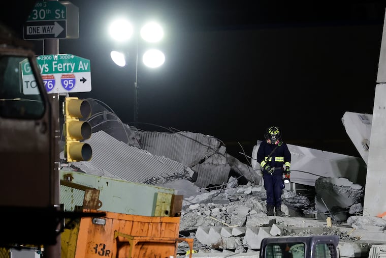 A rescue crew member examines the demolished parking garage in Grays Ferry on Sunday.