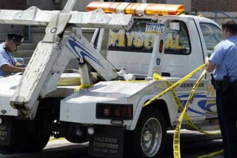Investigators examine the victim's truck after they say he was shot by a rival tow truck operator on Whitaker Avenue, where the driver collapsed. (Jonathan Yu / Staff Photographer)