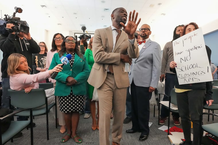 Councilmember Isaiah Thomas, along with members of Council, protests at the school board meeting Thursday.
