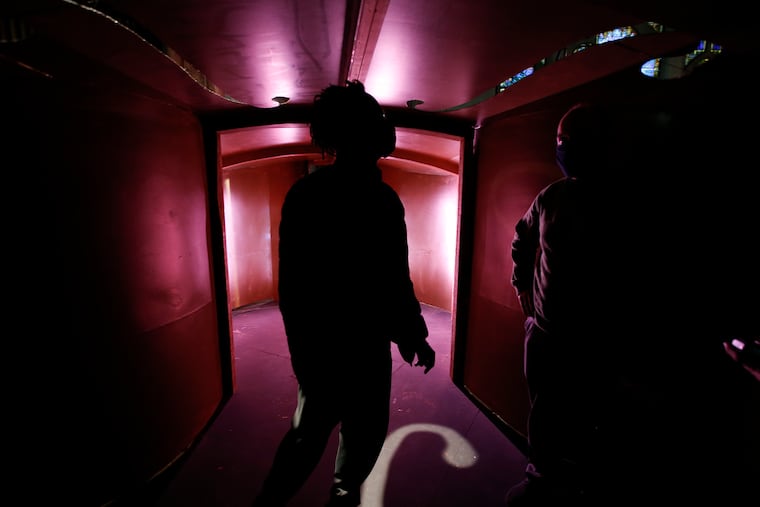 Co-Artist Directors Rich Bradford (left) and Paul Kuhn stand inside an oversize violin that's part of the set for Curio Theatre's theatrical installation about the 18th Century composer and swordfighter Joseph Bologne, Chevalier de Saint-Georges.