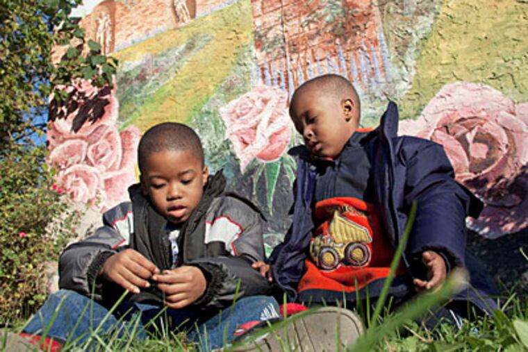 Children sit in Winding Roses Park in the city's Francisville neighborhood.