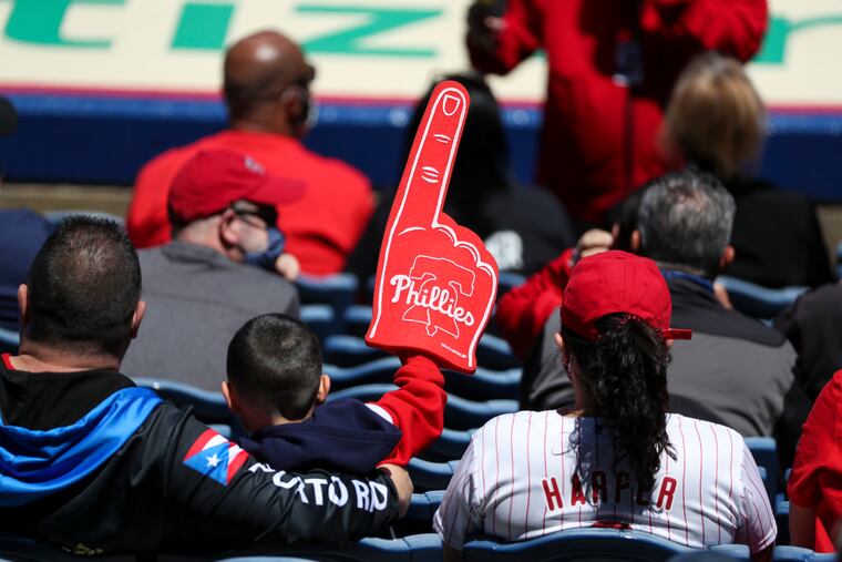 A young fan waves a foam finger during the Phillies game against the Brewers on May 6.
