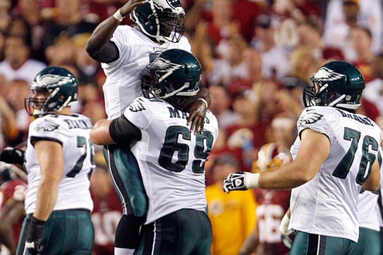 Eagles quarterback Michael Vick celebrates his first quarter touchdown pass with teammate Evan Mathis. (David Maialetti/Staff Photographer)