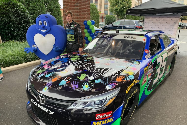 Gift of Life Donor Program’s mascot, “Heartman,†poses with NASCAR driver Joey Gase in front of his No. 35 race car, which is covered in handprints and written messages from transplant donors, recipients, and volunteers.