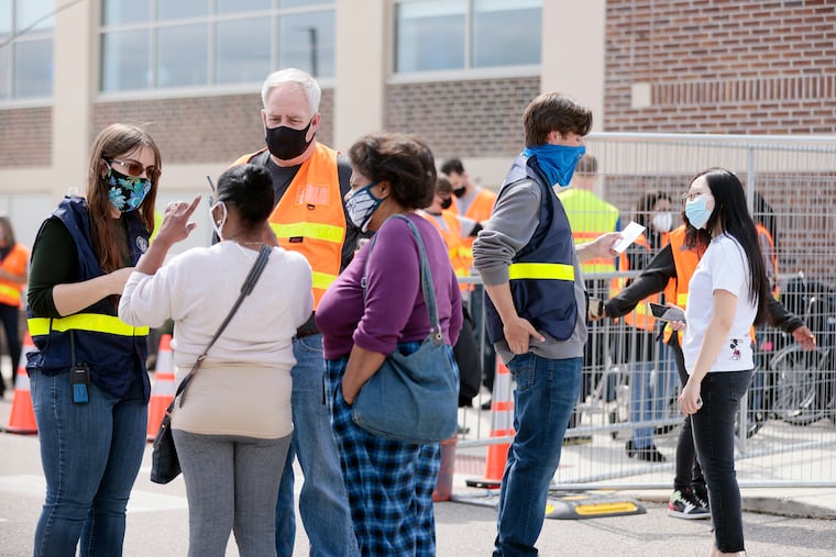 FEMA employees (wearing striped vests) help people who speak languages other than English get the COVID-19 vaccine at FEMA’s mass vaccination site at the Esperanza Community Center in the Hunting Park section of Philadelphia on April 10, 2021.