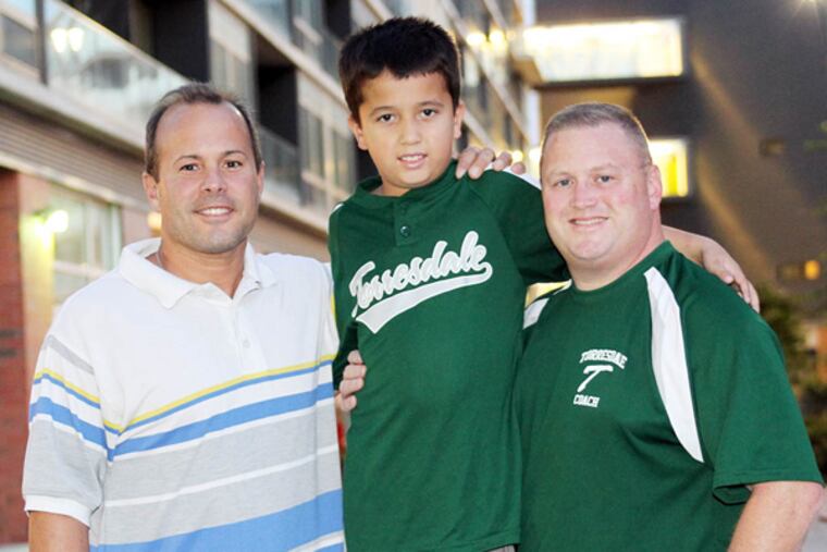 T.J. Ramos, 9, (center) with Philadelphia Police Officers John Callahan (right) and John Pasquarello at the Piazza at Schmidt's on Wednesday, September 25, 2013. ( Yong Kim / Staff Photographer )