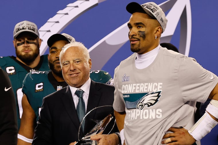 Eagles quarterback Jalen Hurts with Chairman and Chief Executive Officer Jeffrey Lurie holding the NFC Championship trophy.