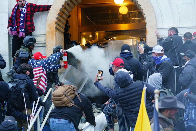 Rioters clashed with police as they tried to gain entrance to a door at the Capitol building on Jan. 6