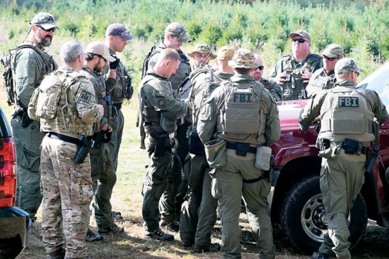 FBI agents gather Wednesday, Oct. 8, 2014, for a briefing in Canadensis on the continued search for Eric Frein. ( ED HILLE / Staff Photographer )