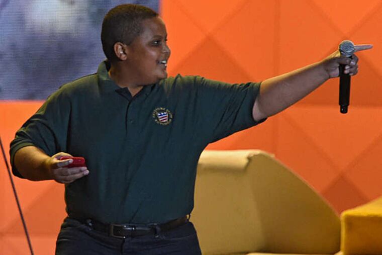 Bobby Hill of the Keystone State Boys Choir leaves the stage -- and points to emcee Mark Wahlberg -- after singing for the Festival of Families audience and receiving a gift from Pope Francis (gift in right hand) Saturday night, September 26, 2015. ( CLEM MURRAY / Staff Photographer )