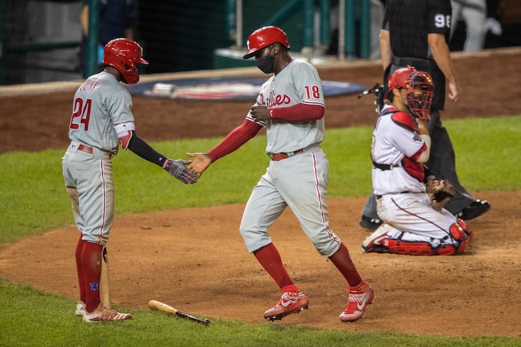 Didi Gregorius (center) is congratulated by teammate Roman Quinn after scoring a run.