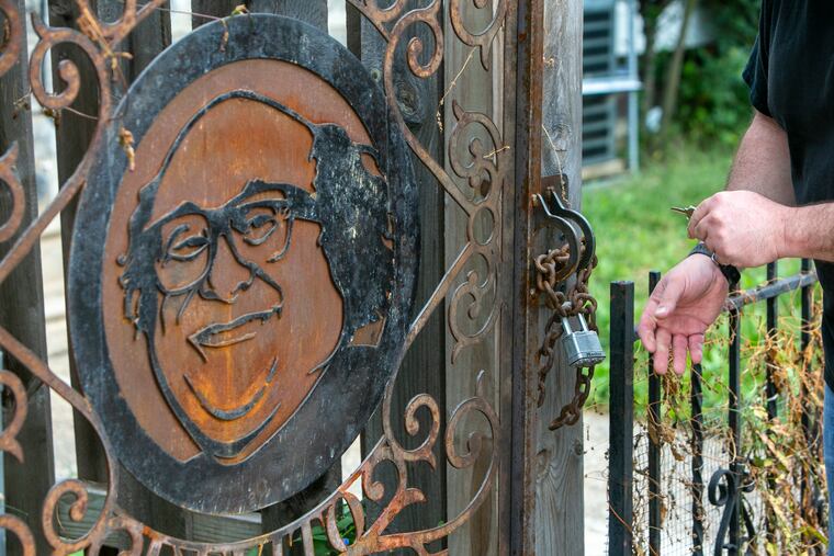 Ken Schapira, owner of North Standard Fabrication & Construction, unlocks the DeVitogate he made for a Kensington alley.