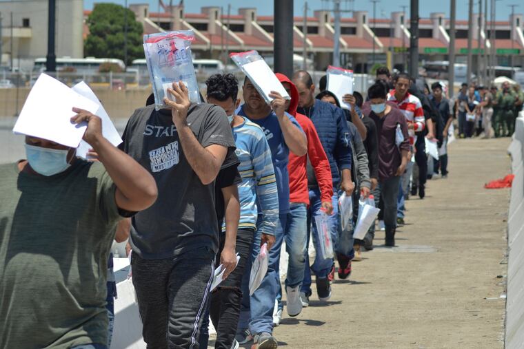 United States Border Patrol officers return a group of migrants back to the Mexico side of the border as Mexican immigration officials check the list, in Nuevo Laredo, Mexico.