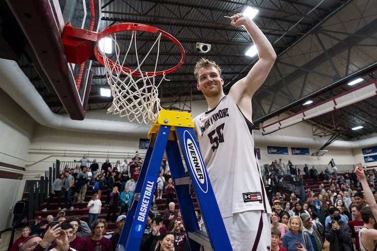 Swarthmore junior Michael Caprise cuts down a piece of net after his shot sent Swarthmore to the Division III Final Four.
