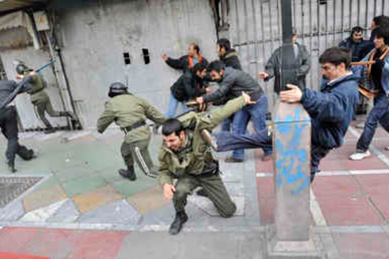 This photo, taken by an individual not employed by the Associated Press and obtained by the AP outside Iran, shows protesters beating police officers during protests in Tehran yesterday.