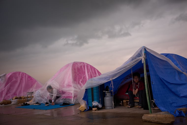 Children displaced from Beirut's southern suburb of Dahiyeh shelter from the rain inside their tents along the coast in Beirut, Lebanon, on Thursday.