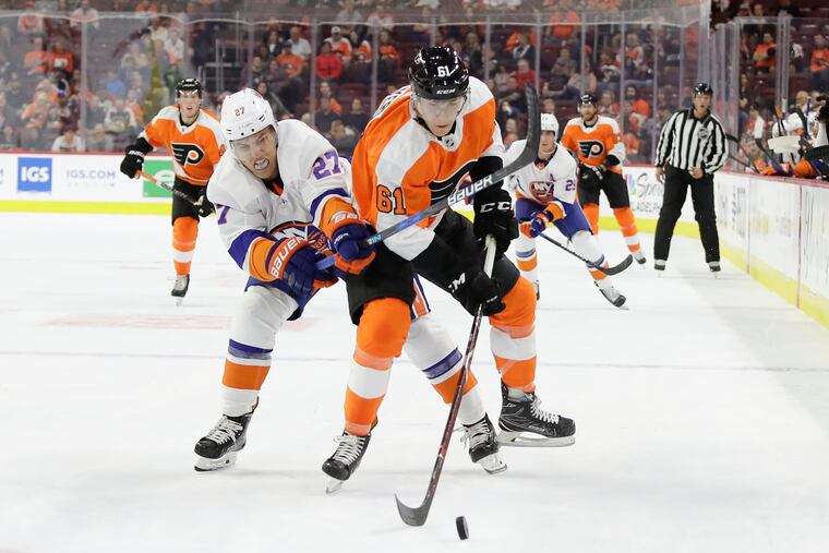 Flyers defenseman Phil Myers goes after the puck against New York Islanders left winger Anders Lee during a preseason game on Sept. 17.