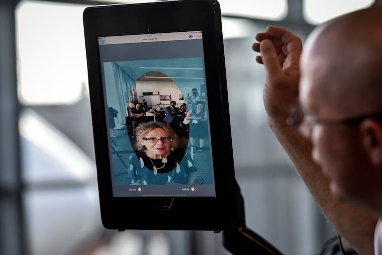 At Dulles International Airport outside Washington, Chad Shane of SAS airlines ushers a boarding passenger through a biometric facial-recognition scanner.