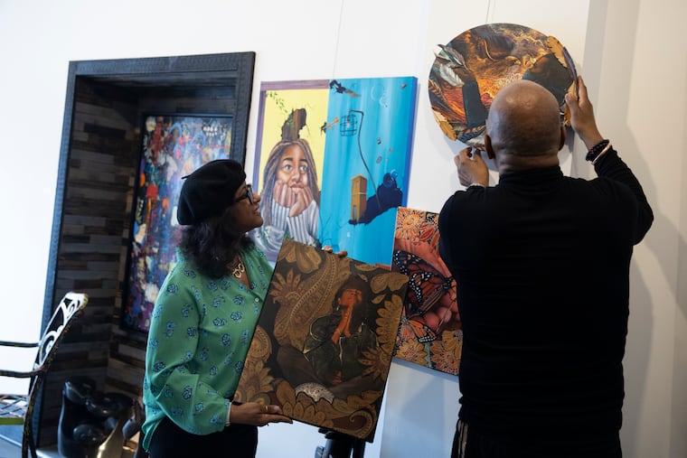 Robyn R. Jones and Adrian Moody adjust pieces by Lydia Boddie-Rice at the Moody Jones Gallery in Glenside. "The Light of Truth" art exhibition opens March 13.