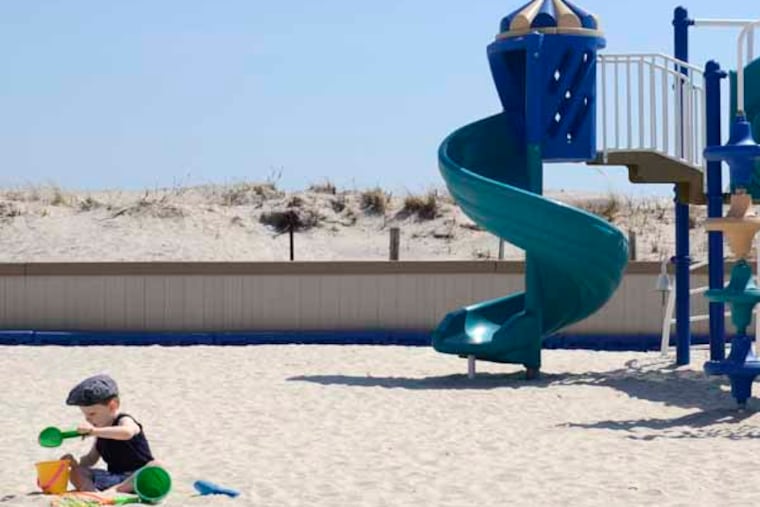 Two year-old Chase Marascio (cq) plays in the playground near 32nd Street where a section of the beach has a sand dune (rear) in Longport April 10, 2013. Longport, formerly opposed to dunes to protect its beach, has changed its mind. Chase was there with this mother, Kristin Marascio (cq). They live year-round in Longport. ( TOM GRALISH / Staff Photographer )
