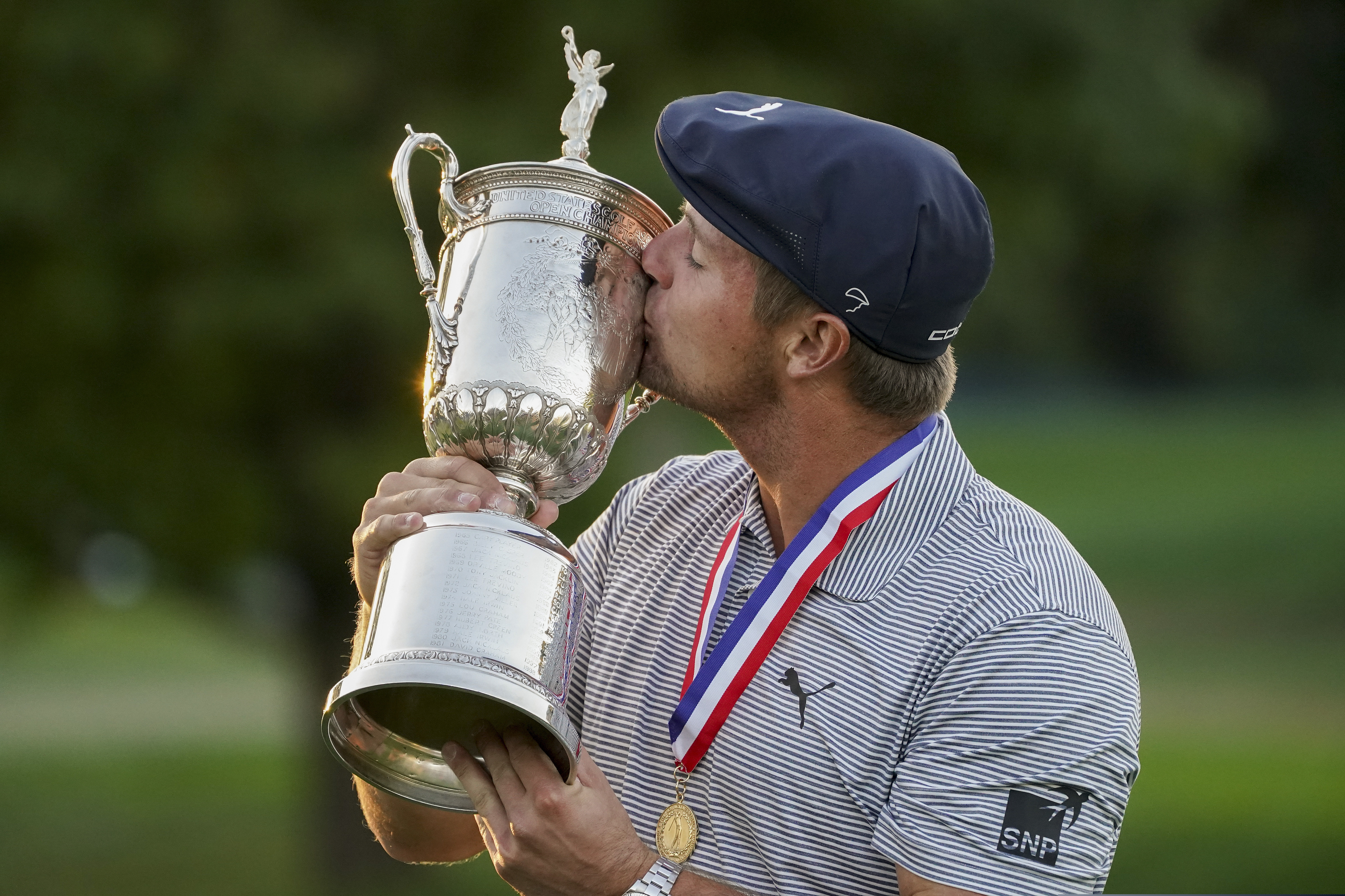 Bryson DeChambeau kisses the winner's trophy after winning US Open Golf Championship Sunday.