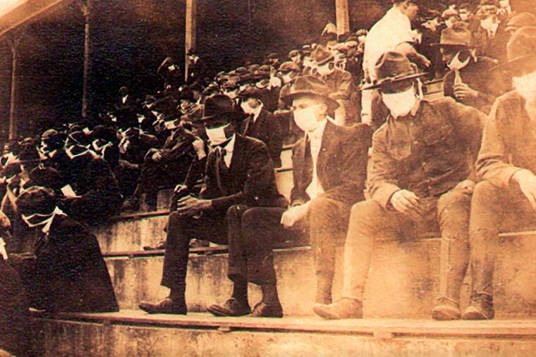 This undated photo provided by Georgia Tech alumnus Andy McNeil shows a Georgia Tech home game during the 1918 college football season. The photo was taken by Georgia Tech student Thomas Carter, who would receive a degree in Mechanical Engineering. The 102-year-old photo could provide a snapshot of sports once live games resume: Fans packed in a campus stadium in the midst of a pandemic wearing masks with a smidge of social distance between them on concrete seats. (Thomas Carter via AP)