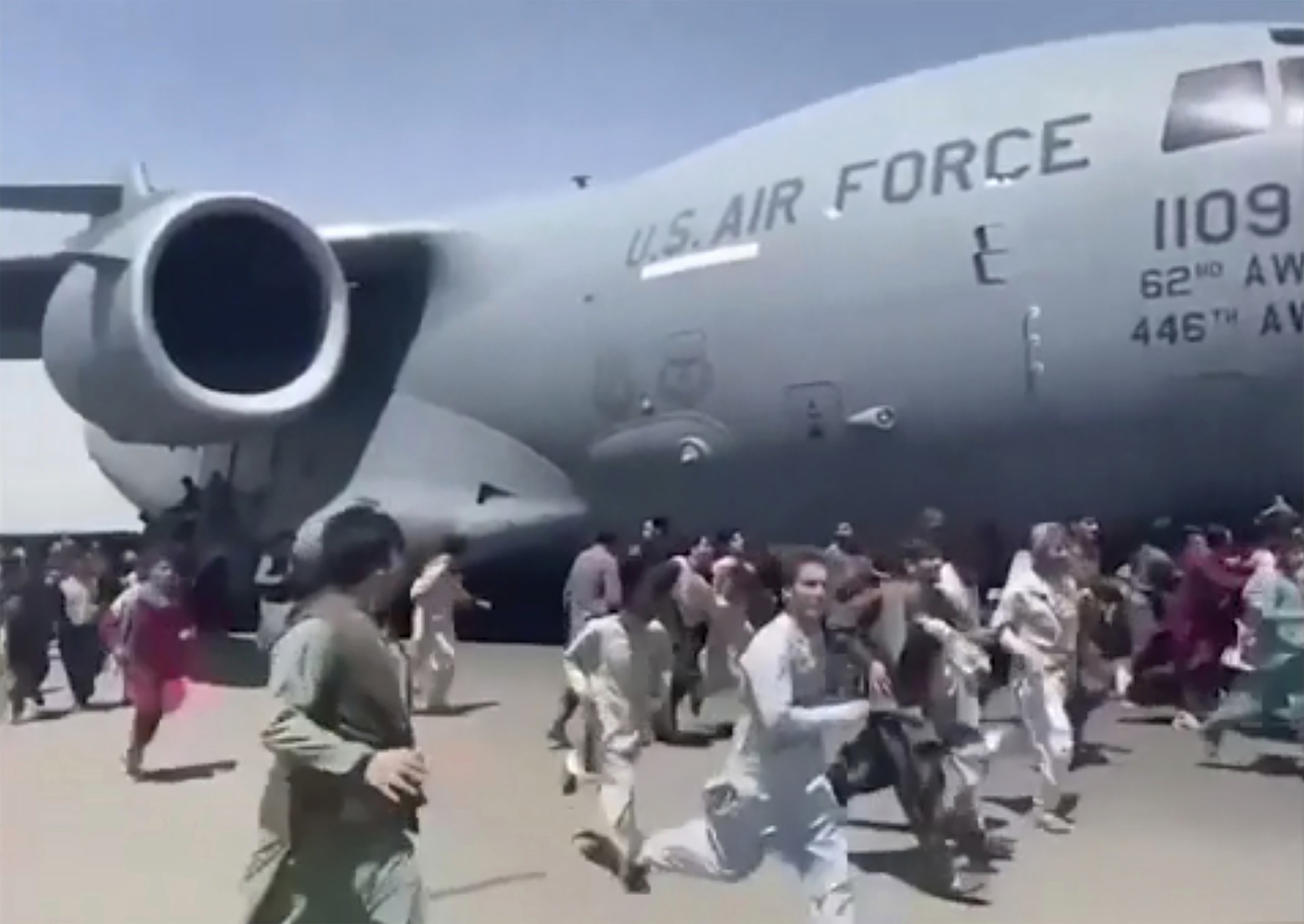 Some hundreds of people run alongside a U.S. Air Force C-17 transport plane as it moves down a runway of the international airport in Kabul on Monday, some so desperate to escape the Taliban that they held onto an American military jet as it took off and fell to their death.