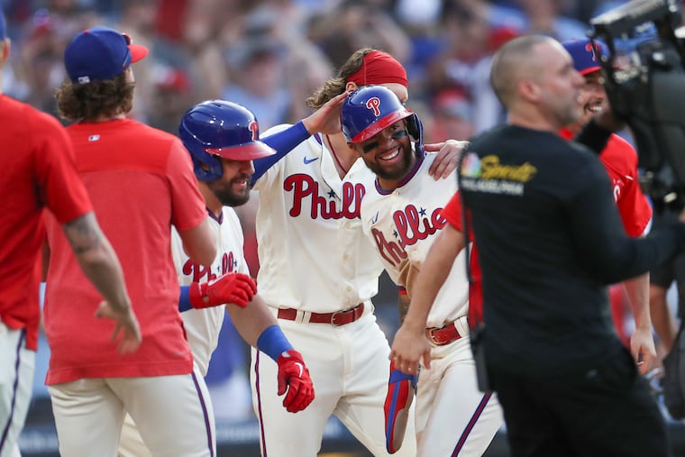 Third baseman Edmundo Sosa (center) celebrates with teammates after he scored the winning run in the 10th inning against the Toronto Blue Jays.