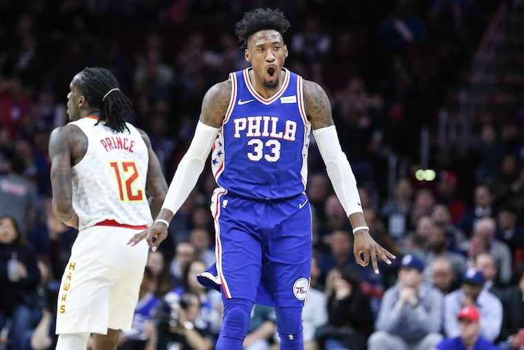 Sixers forward Robert Covington celebrates his three-pointer over Hawks forward Taurean Prince on Wednesday.