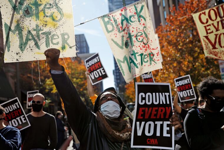 In this Nov. 5, 2020, file photo, Zhanon Morales, 30, of Philadelphia, raises her fist as demonstrators call for all votes to be counted during a rally outside the Pennsylvania Convention Center in Philadelphia, as vote counting in the general election continues.