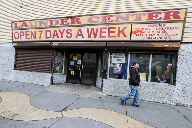 The scene of the Fairhill laundromat where bystanders quickly snatched $2,000 that had fallen to the ground while the owner pursued and shot the fleeing robber.