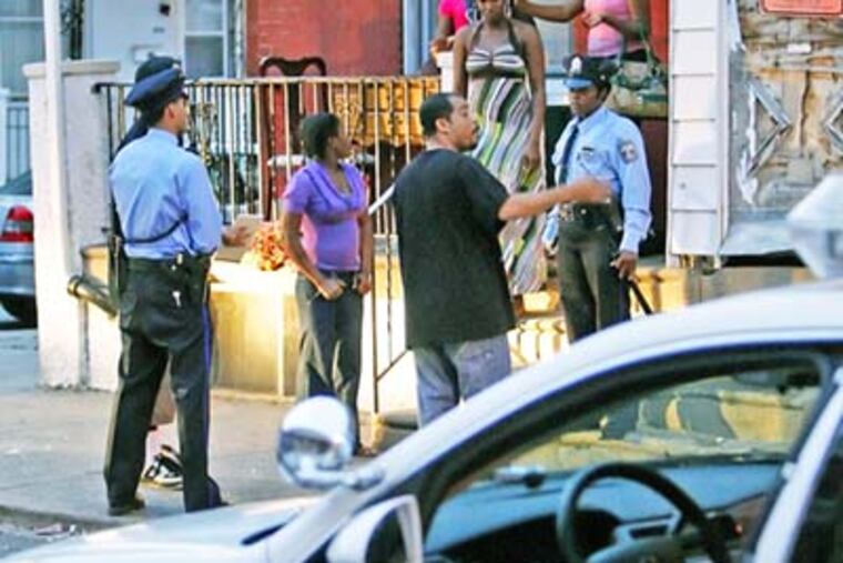12th District Philadelphia Police officers question residents on the 2000 block of Avondale street in Southwest after a vandalism/man with a gun call, Friday. ( Steven M. Falk / Daily News)