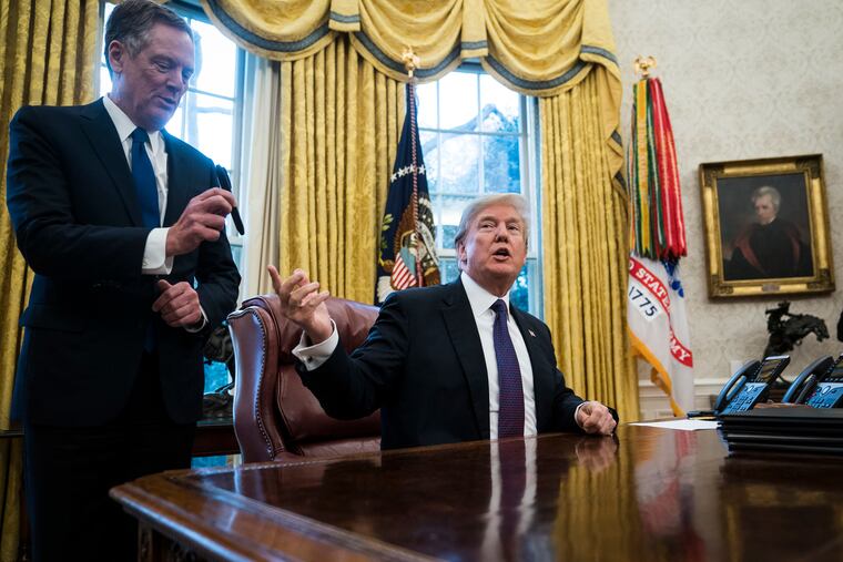 President Donald Trump hands a pen to U.S. Trade Representative Robert Lighthizer, left, after signing Section 201 actions in the Oval Office at the White House on Jan. 23, 2018.