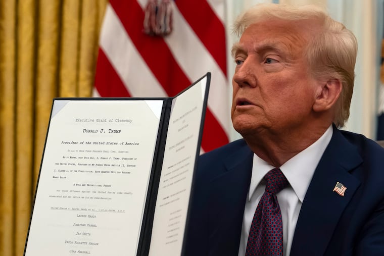 President Donald Trump holds up a signed executive order relating to clemency for anti-abortion protesters as he signs executive orders in the Oval Office of the White House on Thursday in Washington.