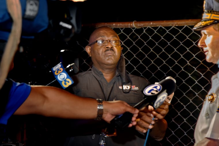 Pete Kane records Philadelphia Police Chief Inspector Scott Small (right) at the scene of a fatal car crash in Mantua in the early morning of Aug. 27, his last night on the streets. Kane, who started in the mailroom at NBC10 47 years ago and rose to become a legendary TV cameraman, retires on Friday.