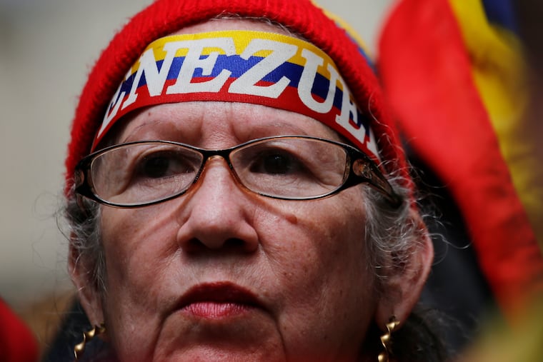A woman waits for the arrival of Juan Guaido at a public plaza where he is expected to speak in Caracas, Venezuela, Friday, Jan. 25, 2019. Guaido is an opposition leader who declared himself interim president on Wednesday.