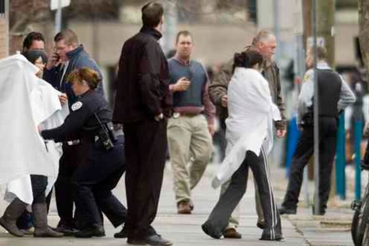 Hostages exit a building (left) near the American Civic Association, site of the shooting rampage in Binghamton, N.Y. Above, survivor Zhanar Tokhtabayev (left), from Kazakhstan, and an unidentified woman embrace after the massacre.