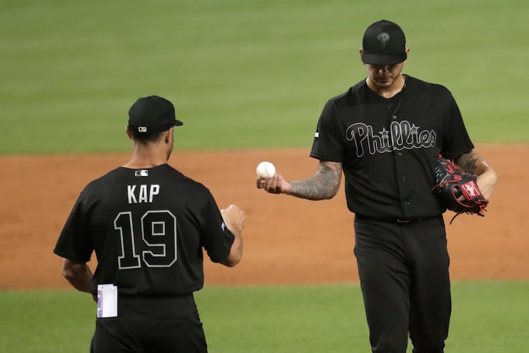 Philadelphia Phillies starting pitcher Vince Velasquez, right, hands the ball to manager Gabe Kapler as he is relieved during the third inning of a baseball game against the Miami Marlins, Friday, Aug. 23, 2019, in Miami. (AP Photo/Lynne Sladky)