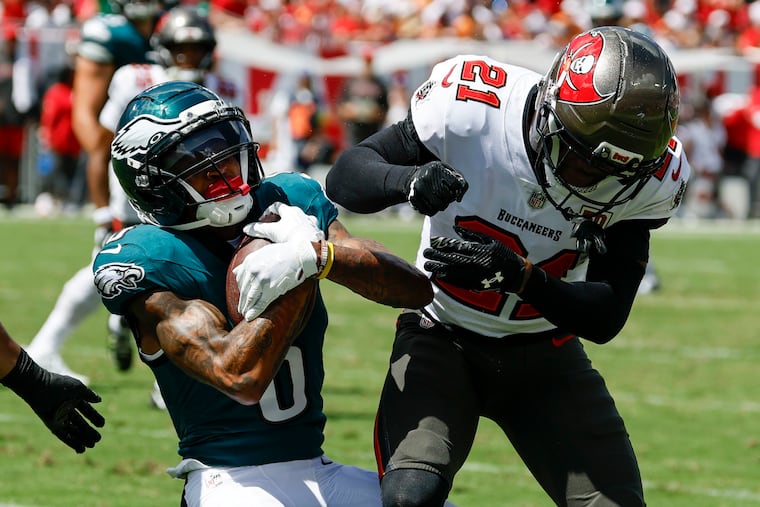 Eagles wide receiver DeVonta Smith (left), here taking a big by Buccaneers cornerback Benjamin Morrison on Sept. 28, always pops right back up and has done so throughout his football career.
